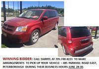 Front left quarter view of red 2009 Dodge Caravan parked outdoors