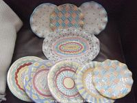Main overview of oval tray with round and scalloped plates on sofa
