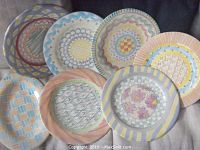 Six round charger plates displayed together on fabric background