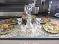 Vammes le Chatel crystal vase surrounded by twelve Limoges fruit motif plates and two Gorham crystal candlesticks on placemats