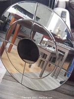 Front view showing the round sectional wall mirror with unusual circular center opening and metal framework sections.