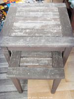 Top view of two stacked rustic solid wood nesting tables showing weathered slatted tops.
