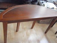 Full view of the half-moon shaped couch table showing the overall design and cherry finish on wood.