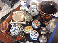 Overview photo of all items on a table including trinket boxes, vases, bell and small collectibles
