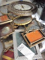 Photo showing multiple tabletop frames stacked with the quartz wall clock on top.