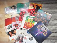 Photo showing a spread of vinyl LP record sleeves with visible covers from The Clash, Toto, Doors, and others.