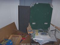 Green fabric Surfgear Big Daddy Beach Chair on metal frame with plastic armrests, visible next to packed boxes and items