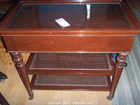 Top view of the wooden serving cart showing the glass inset top surface and part of the front panel.