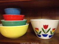 Wide view showing all four nested Pyrex primary bowls with Fire King tulip bowl beside them.