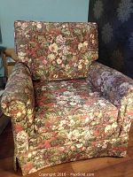 Front angled view of the floral patterned armchair showing seat, armrest, and backrest cushions