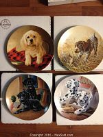 Four Bradford Exchange puppy collector plates displayed in their original boxes with certificates.