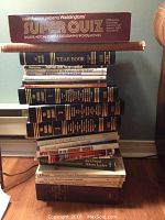 Full lot of stacked books and game box showing titles and condition