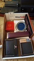 Top-down shot showing silver frame, watch boxes, wallets and jewelry box