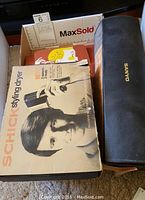 Photo of Schick styling dryer box with black and white photo of man holding dryer and Sanyo massager case