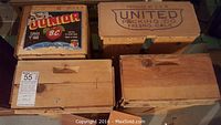 Four wooden crates, two with brand labels and two plain, showing wear and scratches.