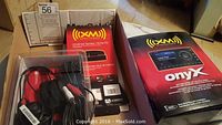 Photo showing XM satellite radio Onyx car kit box and Universal Xpress home kit box with cables inside.