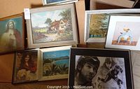 Eight framed pictures arranged on a surface showing variety of subjects including religious art, country cottages, landscape and portraits.