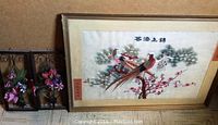 Overall view of three art pieces grouped together showing the framed peacock fabric art and two plastic flower wall decor pieces