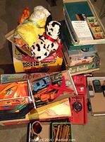 Overview of lot showing Rock ’Em Robots box with plush animals, Conflict game, die‐cast cars, plastic truck