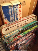 Photo showing the boxed vintage NHL tabletop hockey game alongside Mattel Talking Football Game box