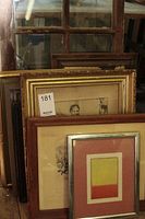 Several framed artworks and a multi-pane wood frame leaning together