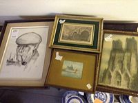 Four framed prints arranged together including a pencil sketch, colored castle print, architectural print, and a small framed map/drawing.