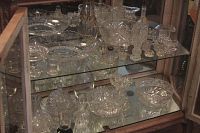 Two shelves of assorted cut glass and crystal bowls and small items