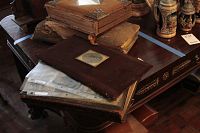 Three leather bound photo albums stacked on a table showing covers