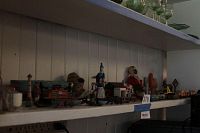 Shelf of assorted miniature toys including tin vehicles, model buildings, figurines and collectibles