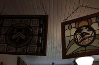 Both stained glass panels hanging side by side, wood frames and chains visible