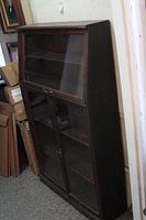 Full side view of the wooden and glass display cabinet showing overall structure and condition.