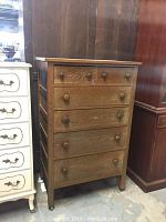 Front view of wooden tall boy chest with six drawers and visible wood grain finish.