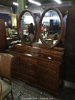 Front view of Link Taylor wooden dresser with two large oval mirrors attached on rails, showing 19 drawers with metal handles and minor wear.