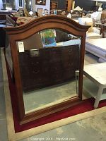 Front view of the beveled glass wood mirror with dark wood frame, showing the arch top shape and clear reflection.