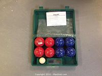 Full set of bocce balls in green carrying case, including 4 red, 4 blue balls, white jack ball, and instruction sheet.