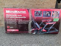 Front of unopened MotoMaster Motorcycle Jack box showing brand name, jack image and 1500 lb capacity.