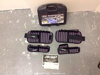 Photo of adjustable ankle and wrist weights along with an instruction manual in front of a wall.