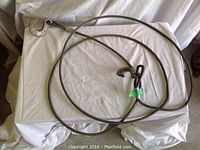 Tow cable laid out on white cloth background showing full length and hooks at both ends.