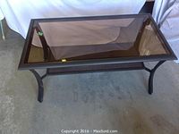 Top-down view of the rectangular patio coffee table showing the smoked glass top and metal frame structure.