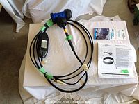 Full lot laid out on cloth showing heating cable, blue connectors, control unit, and printed installation instructions.