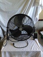 Full front view of the fan showing circular grille, 3 blades, and power cord.