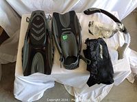 Top view of snorkel kit showing flippers, snorkel, goggles, and carry bag arranged neatly on white cloth
