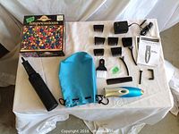 Photo showing the Remington Precision Pro hair cutting kit parts: clipper, guards, scissors, comb, charger, cleaning brush, manual, alongside the puzzle box and air pump bag.