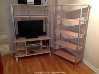 Two shelving units side by side; left is a media shelving unit with TV and speakers placed, right is an open shelving unit with five shelves and metal frame.