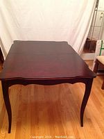 Photo of the wooden dining table top with Jacobean finish and scalloped edges.