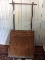 Full front view of the wooden cranberry bog shovel showing the large flat blade and crossbar handle.