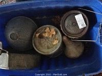 Top view of a blue bin containing multiple metal items including strainers, a bait bucket, and small metal containers.