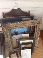 Photo showing several picture frames stacked together plus a large Federal style mirror with cherry wood frame.