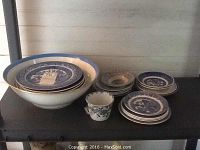 Photo showing a large bowl and stacked blue and white decorative plates with some chipping and cracks evident.