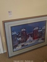 Framed artwork leaning against a wall, showing full piece and frame.